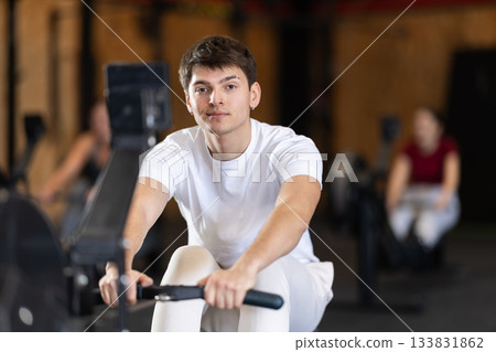 Man exercising on a rowing machine 133831862