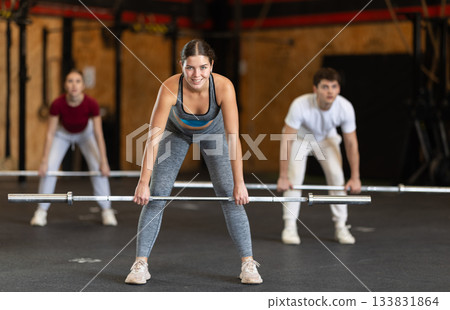 Woman in top lifting barbell 133831864
