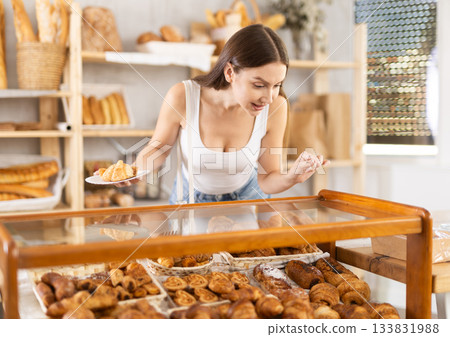 Young woman buyer chooses pastries in bakery 133831988