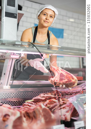 Girl seller works in specialized butcher shop Girl seller works in specialized butcher shop 133832001