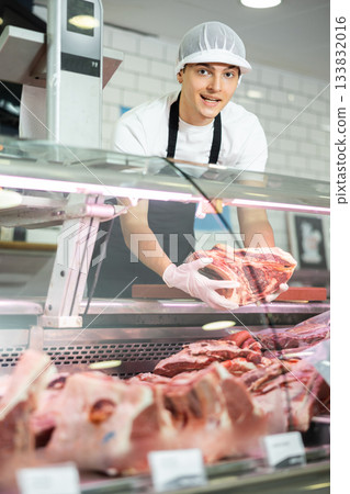 Guy seller works in specialized butcher shop 133832016