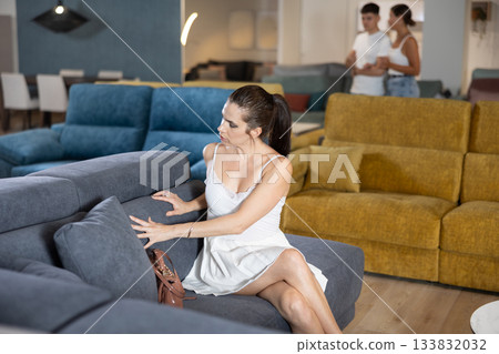 Young woman choosing convenient sofa in furniture shop Young woman choosing convenient sofa in furniture shop 133832032