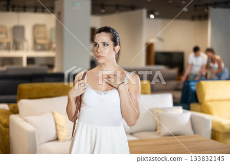 Young woman watching delightedly large stock of goods in furniture shop 133832145
