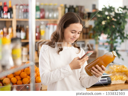 Teenage girl scanning qr code of peach juice 133832303