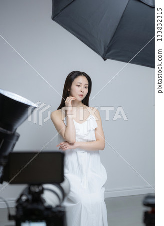 Studio photography of a female model and lighting equipment: portrait of a beauty image 133832315
