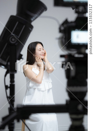 Studio photography of a female model and lighting equipment: portrait of a beauty image 133832317