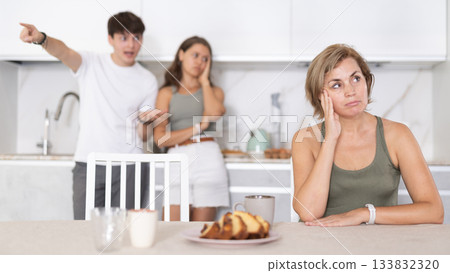 Portrait of thoughtful woman who had conflict with adult children while cooking dinner in kitchen 133832320