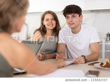 Married couple of clients listen attentively and intently to woman of seller 133832337