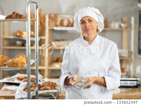 Adult female baker with dough scraper Adult female baker with dough scraper 133832347