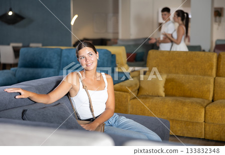 Young woman chooses sofa in store Young woman chooses sofa in store 133832348