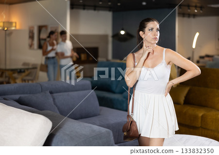 Adult woman chooses sofa in store 133832350
