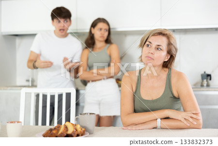 Adult children guy and girl are fighting with elderly woman mother. Adult children guy and girl are fighting with elderly woman mother. 133832373