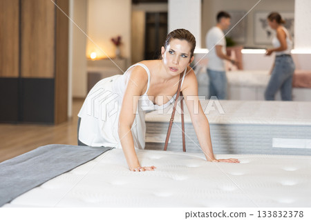 Adult woman chooses mattress in store 133832378