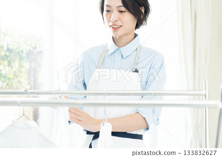 年輕的女士掛洗衣 133832627