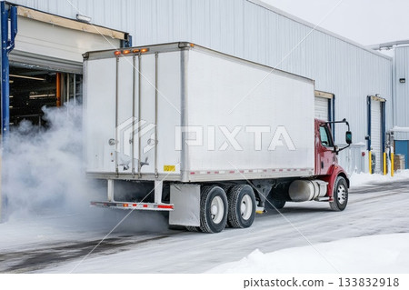 Refrigerated Truck Departing Cold Storage Warehouse in Winter Scene 133832918