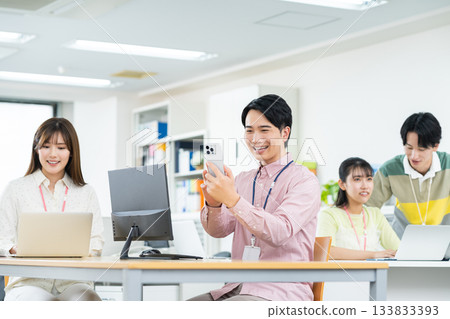 Young engineer using a smartphone in the office Young engineer using a smartphone in the office 133833393