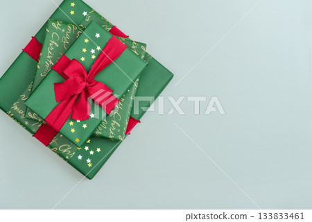 Stack of green gift boxes with red ribbon Stack of green gift boxes with red ribbon 133833461