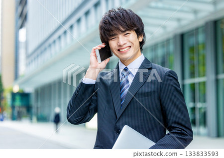 Businessman talking on a smartphone in an office district Businessman talking on a smartphone in an office district 133833593