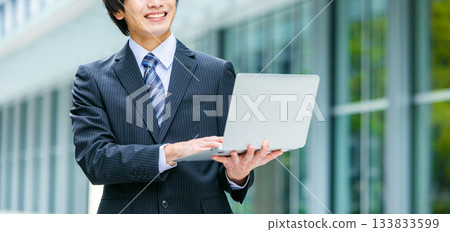 Businessman with laptop in office 133833599