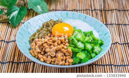 一碗香糯的夏日米飯，上面鋪著納豆、秋葵、山藥泥、海苔碎和蛋黃。 133833940