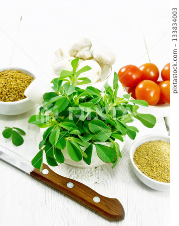 Fenugreek green in mortar on wooden board 133834003