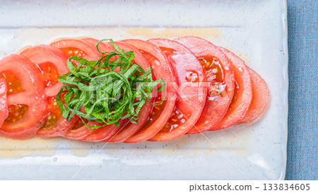 A refreshing summer appetizer of thinly sliced chilled tomatoes and green shiso leaves A refreshing summer appetizer of thinly sliced chilled tomatoes and green shiso leaves 133834605