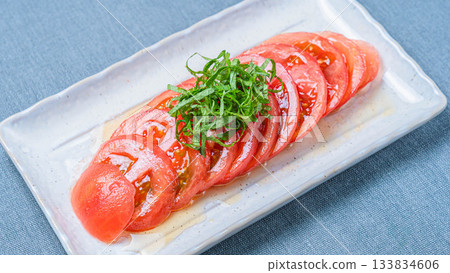 清爽的夏季開胃菜,由切成薄片的冰番茄和綠色紫蘇葉組成 清爽的夏季開胃菜,由切成薄片的冰番茄和綠色紫蘇葉組成 133834606