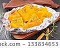 Pumpkin baked in foil on dark board 133834653