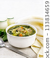 Soup with meatballs and pasta in bowl on granite table 133834659