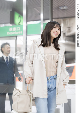 A woman moving around with a suitcase at a station or airport, the image of going on a trip or outing 133837645