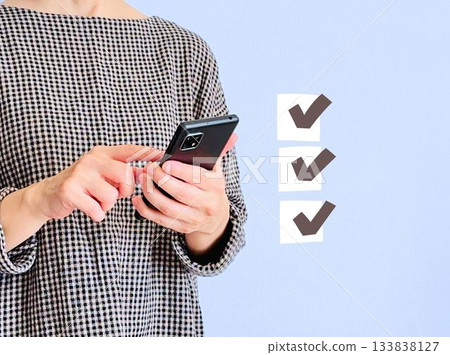 一位女士正在使用智慧型手機任務管理應用程式 一位女士正在使用智慧型手機任務管理應用程式 133838127