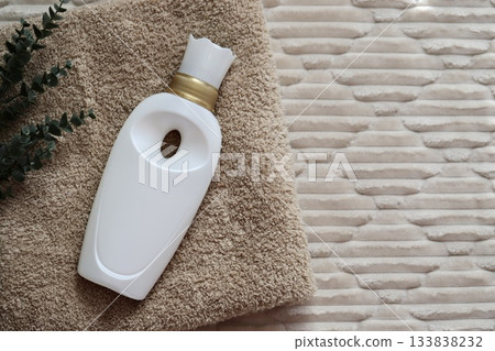 Fabric softener placed on a fluffy bath towel 133838232