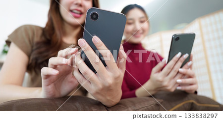 Social Connection. Two friends enjoying smartphone interaction and sharing moments. Social Connection. Two friends enjoying smartphone interaction and sharing moments. 133838297