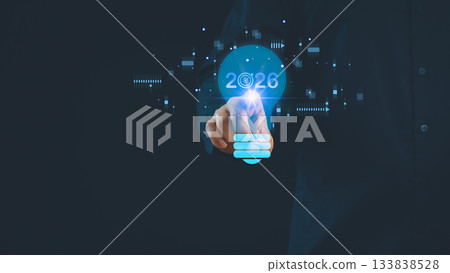 Futuristic business concept showing hand businessman pointing to glowing light bulb with 2026 target, symbolizing innovation, vision, technology trends, and strategic planning for future success. 133838528