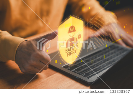 Safety first concept with worker protection icon and thumbs up on laptop, symbolizing workplace safety, industrial security and occupational health for business operations and construction management. 133838567