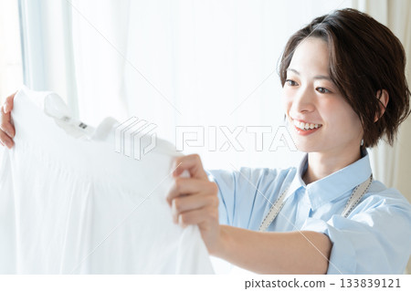 年輕的女士掛洗衣 133839121