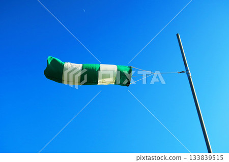A scene of windsocks fluttering in the wind and blue sky 133839515