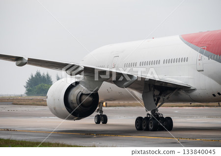 Wing and turbofan engine mounted under large aircraft on taxiway Wing and turbofan engine mounted under large aircraft on taxiway 133840045