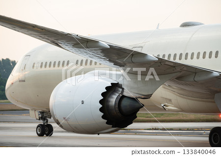 Close-up rear view turbofan engine mounted under the wing of wide body plane 133840046