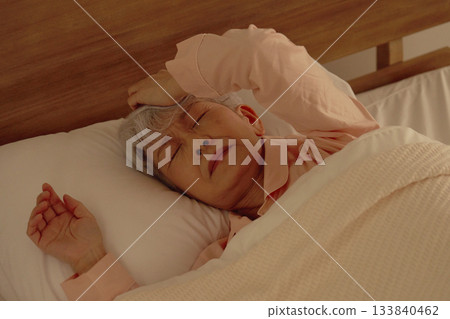 一位熟睡的老婦人在臥室裡做惡夢 133840462