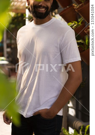Man is standing on sunlit garden patio in flat design with wooden lattice, vertical plant rack 133841084