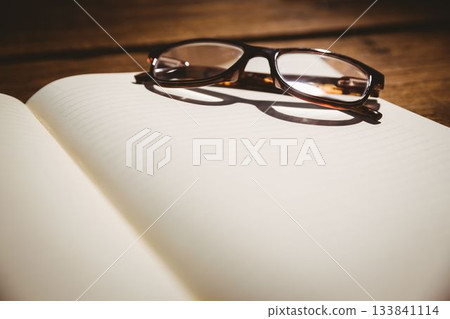 Close-up of eyeglasses at desk 133841114