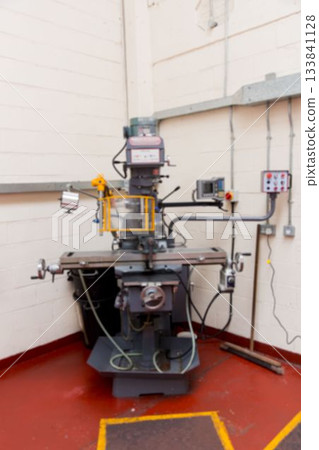 Vertical milling machine showing yellow safety guard, digital readout in flat design with red floor 133841128