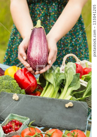 Hands holding an aubergine 133841205