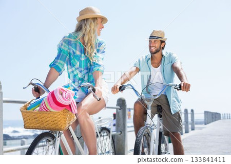 Couple on bike ride by the beach Couple on bike ride by the beach 133841411