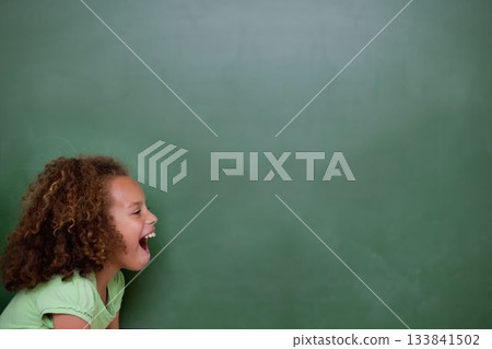 Girl is leaning forward with curly hair against green chalkboard in flat design, showing open mouth 133841502