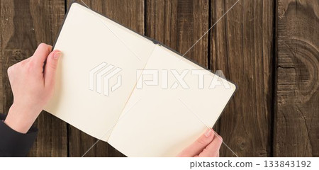 Overhead view of hand holding book Overhead view of hand holding book 133843192