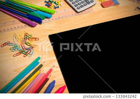 Flat design is showing wooden desk with highlighters, markers, calculator, crayons and black tablet Flat design is showing wooden desk with highlighters, markers, calculator, crayons and black tablet 133843242