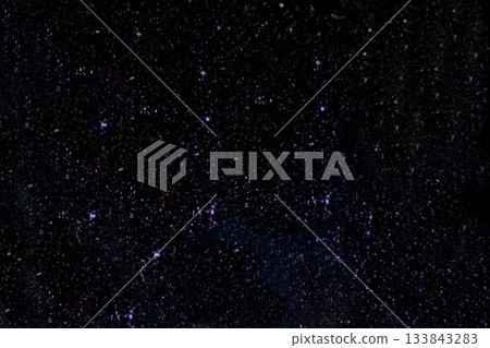 Vector star field is appearing on deep black background, with countless white and purple speckles 133843283