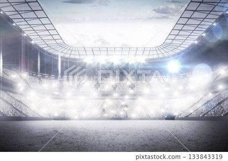Empty stadium is showing flat floodlights lighting stands and field under cloudy sky 133843319